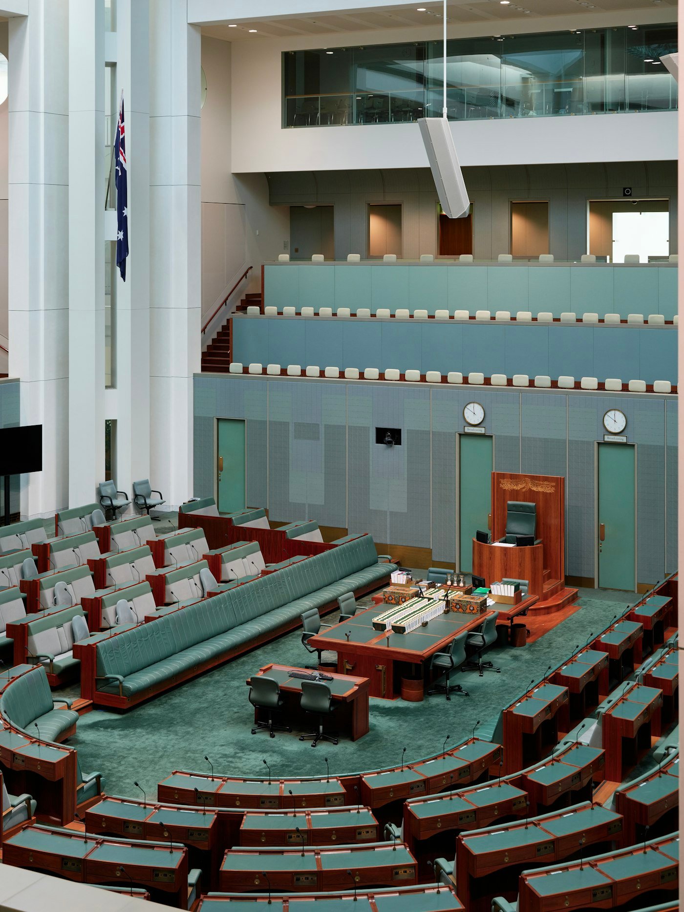 An empty parliamentary chamber with curved rows of desks